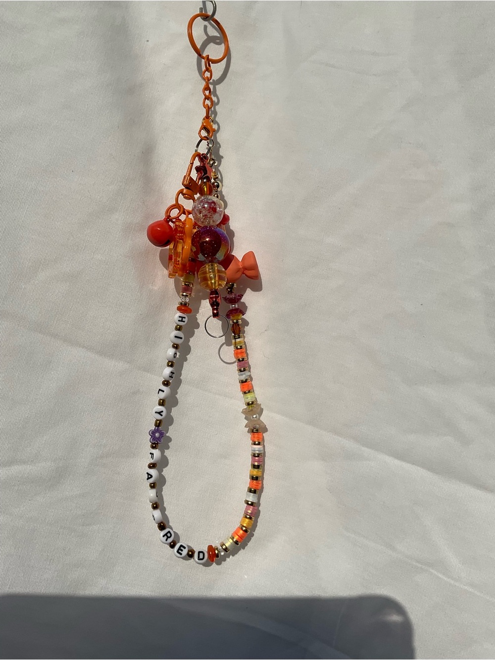 Beaded Orange Keychain with beaded bar. “Highly Favored”